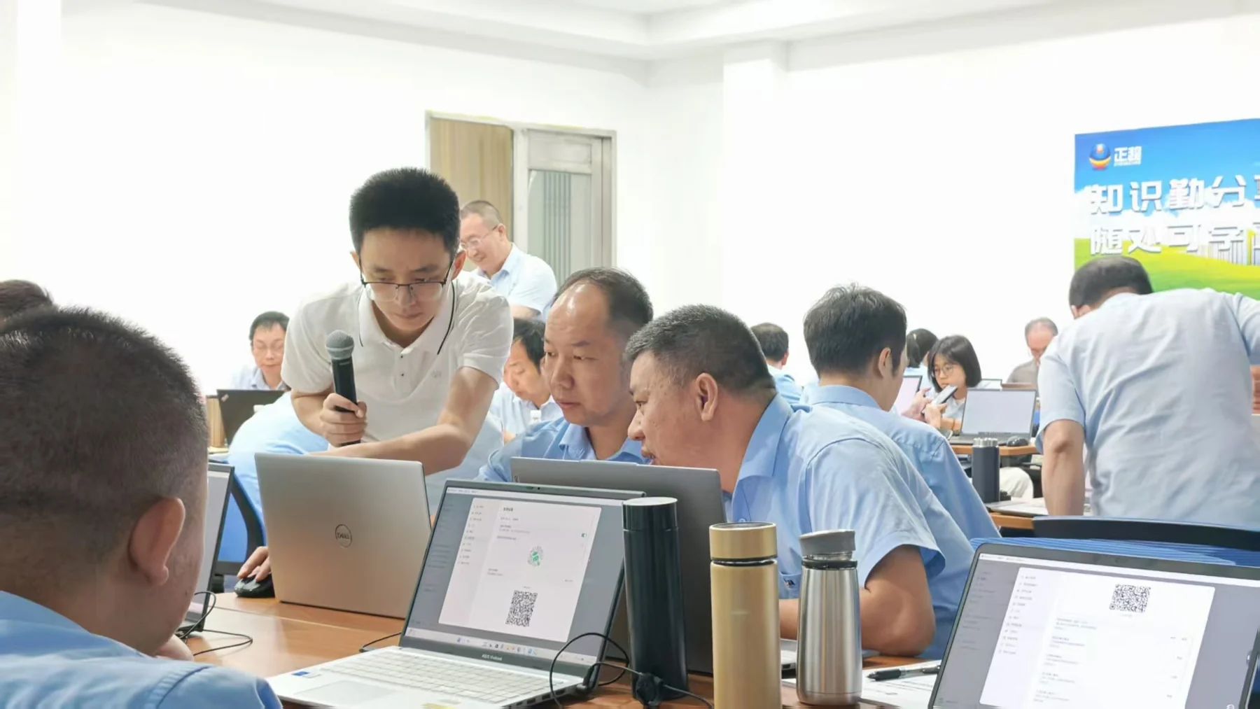 黄啊码俯身在学员电脑旁进行一对一实操辅导